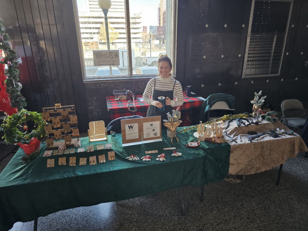 owner at a craft fair smiling